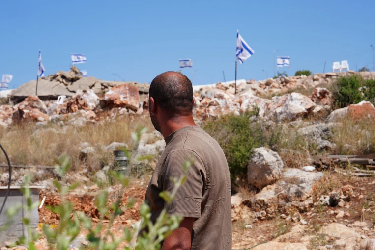 Παλαιστίνιος κοιτάζει την Ισραηλινή σημαία σε εβραϊκό οικισμό στη Δυτική Όχθη / Reuters