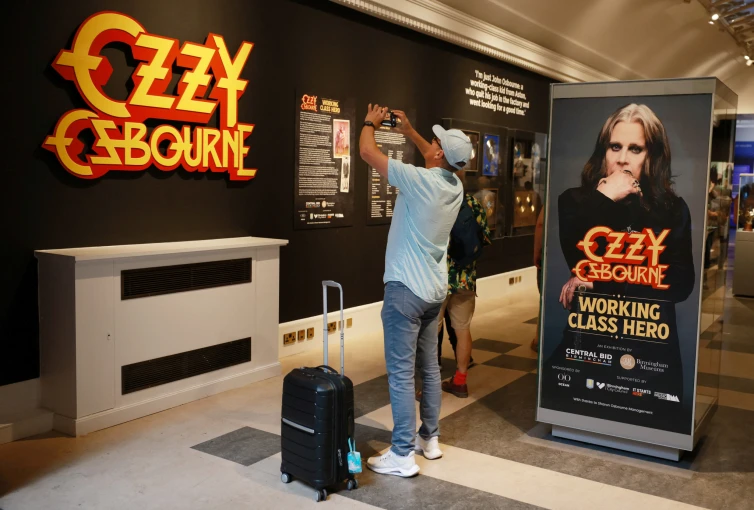 A visitor uses his mobile phone to take photographs as he visits the Ozzy Osbourne exhibition at Birmingham Museum and Art Gallery ahead of Black Sabbath