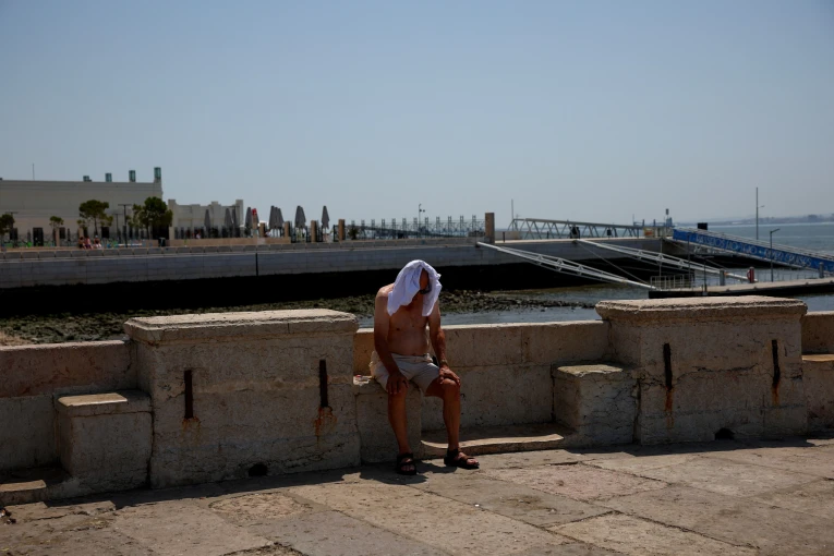 Ένας άνδρας προσπαθεί να προστατευτεί από τον καυτό ήλιο.Πηγή: Reuters