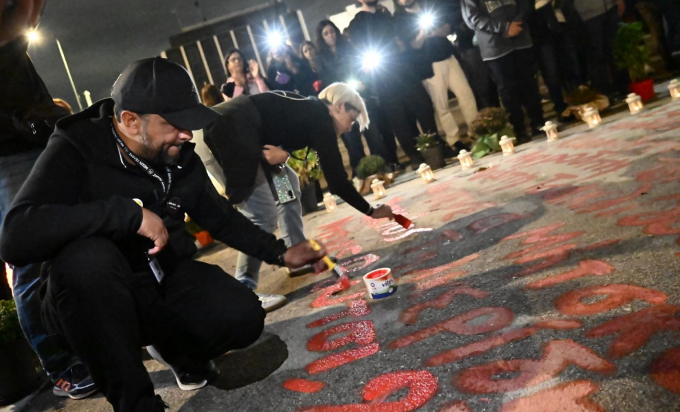 Ο Πάνος Ρούτσι γράφει το όνομα του γιου του, θύματος της τραγωδίας των Τεμπών, μπροστά από τη Βουλή/Φωτ. EUROKINISSI