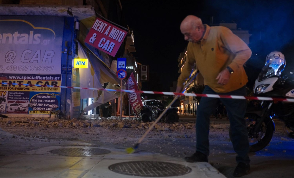 Γείτονας σκουπίζει τα συντρίμια από το μπαλκόνι που έπεσε στον δρόμο/Φωτ. EUROKINISSI