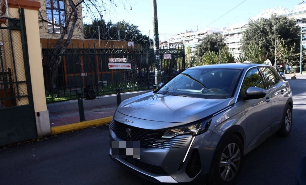 Το αυτοκίνητο της αστυνομίας με τους τέσσερις συλληφθέντες τη στιγμή που περνάει την είσοδο των δικαστηρίων της οδού Ευελπίδων/Φωτ. INTIME