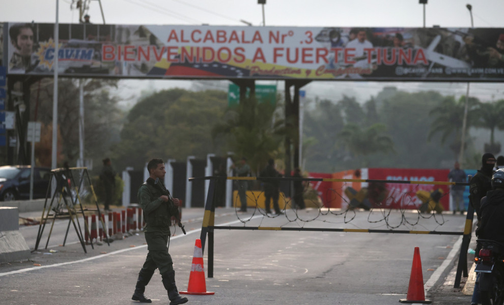 Ένοπλος αξιωματικός φρουρεί ένα σημείο ελέγχου κοντά στο Fuerte Tiuna (Φρούριο Tiuna), όπου βρίσκεται η έδρα του Υπουργείου Άμυνας της Βενεζουέλας, στο Καράκας (φωτο: ΑΠΕ-ΜΠΕ/EPA/MIGUEL GUTIERREZ
