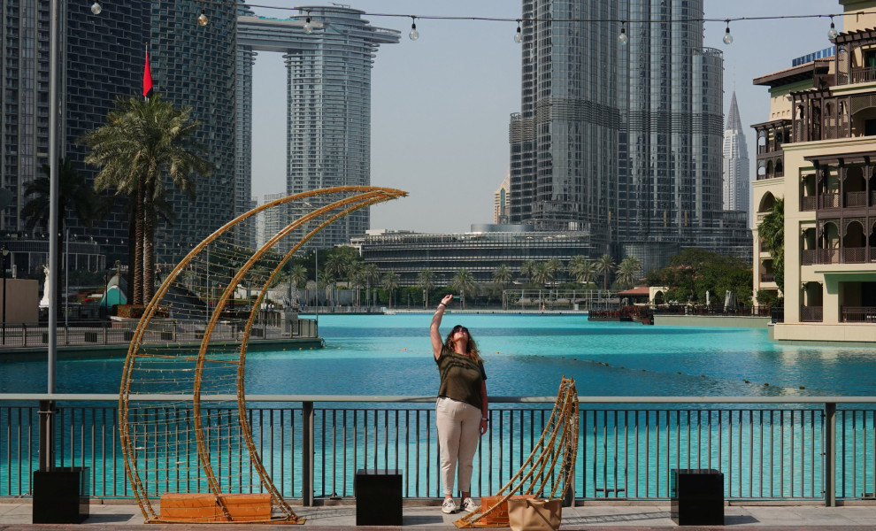 Τουρίστρια φωτογραφίζει ιρανικούς πυραύλους που εισέρχονται στον ουρανό πάνω από το Ντουμπάι / Reuters