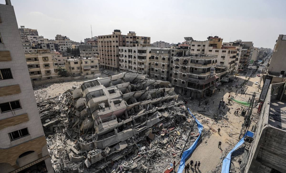 epa10907219 An aerial view shows people gathering near the destroyed Al-Aklouk Tower following Israeli air strikes, in Gaza City, 08 October 2023. The air strikes, in retaliation for the 07 October Hamas rocket attacks on Israel, have killed over 300 peop