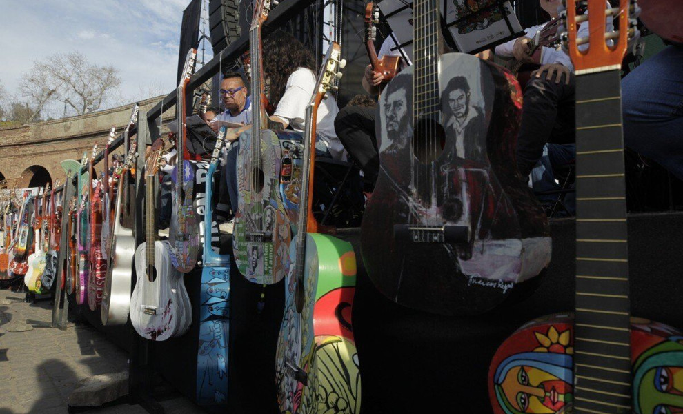 epa10870823 Musicians and attendees play guitars during an event in honor of Víctor Jara in Santiago, Chile, 19 September 2023. During the event, tribute was paid to the singer-songwriter who was tortured and murdered by the dictatorship of Augusto Pinoch