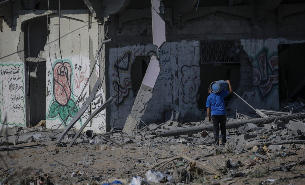 epa10913536 A Palestinian man carriea a gas tank among the rubble following an Israeli air strike in the west of Jablaiya refugee camp, northern Gaza Strip, following an Israeli air strike, 11 October 2023. More than 1,000 Palestinians have been killed an