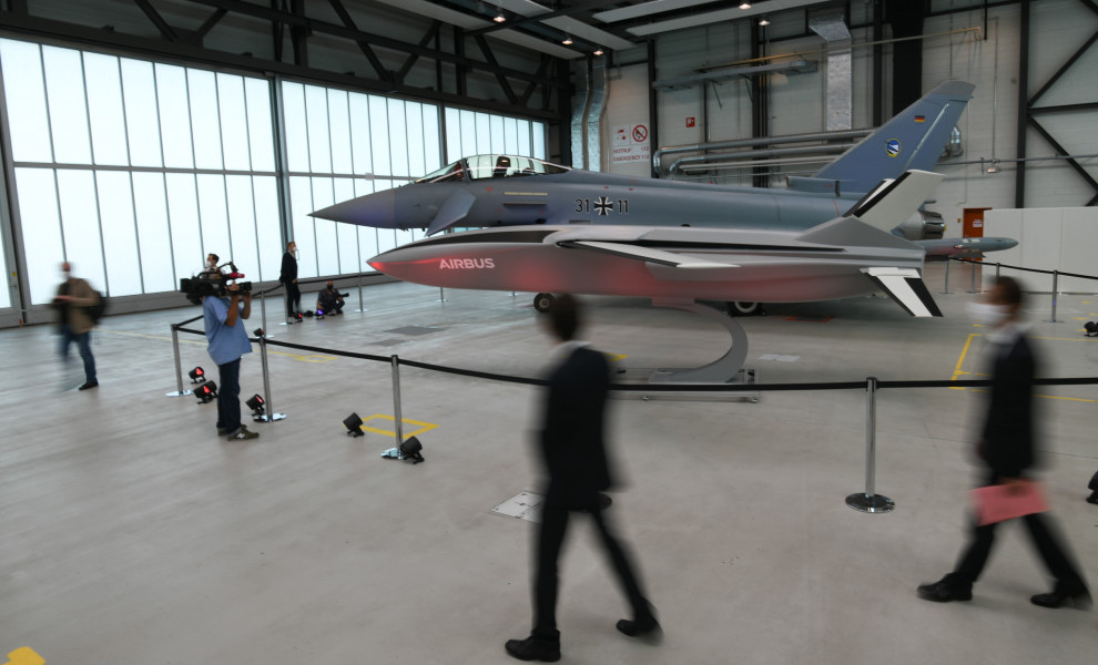Ένα μοντέλο drone μεταφοράς και ένα μαχητικό Eurofighter εκτίθενται σε υπόστεγο κατά τη διάρκεια επίσκεψης Γερμανών και Γάλλων αξιωματούχων του Υπουργείου Άμυνας στο κέντρο στρατιωτικής αεροπορίας της Airbus στο Μάντσινγκ της Γερμανίας (ΦΩΤΟ: ΑΠΕ-ΜΠΕ/EPA/