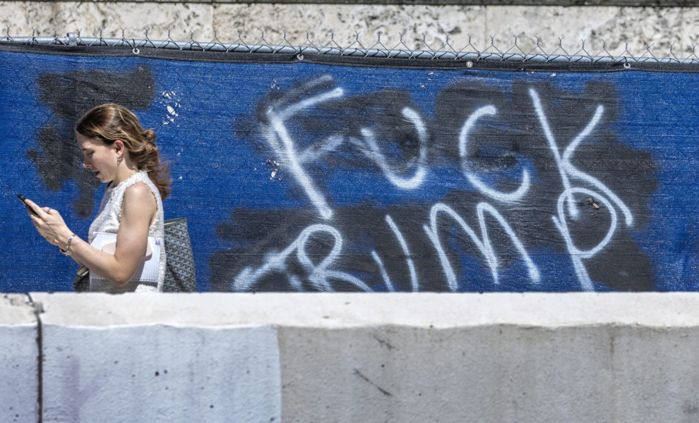 epa10778817 A person walks in front of a graffiti against former US President Donald Trump, outside the James Lawrence King Federal Justice Building were Carlos De Oliveira, a property manager at Trump's resort, Mar-a-Lago, is supposed to appear, in Miami