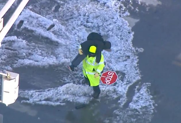 Σχολικός τροχονόμος κουβαλά παιδί στους ώμους του για να περάσει παγωμένο δρόμο στο Σικάγο